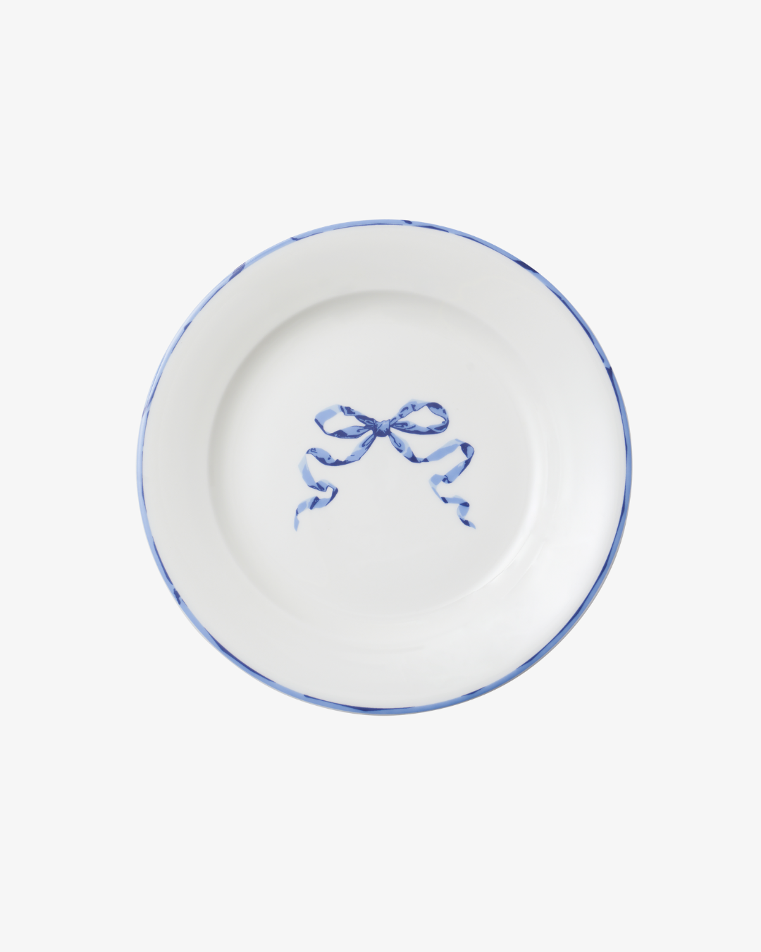 White plate with blue rim and decorative bow design on a white background