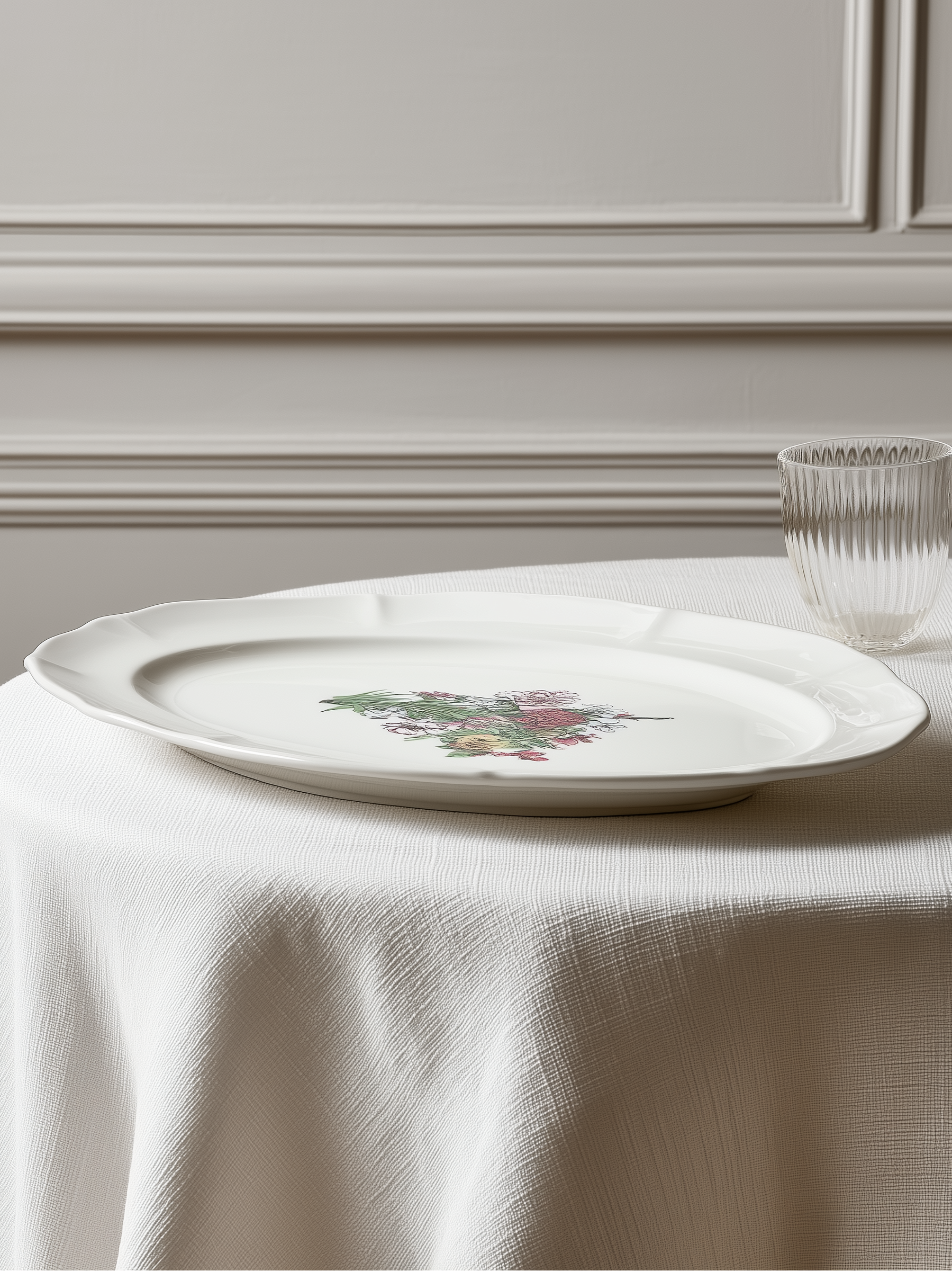 White plate with floral design on a tablecloth against a neutral wall