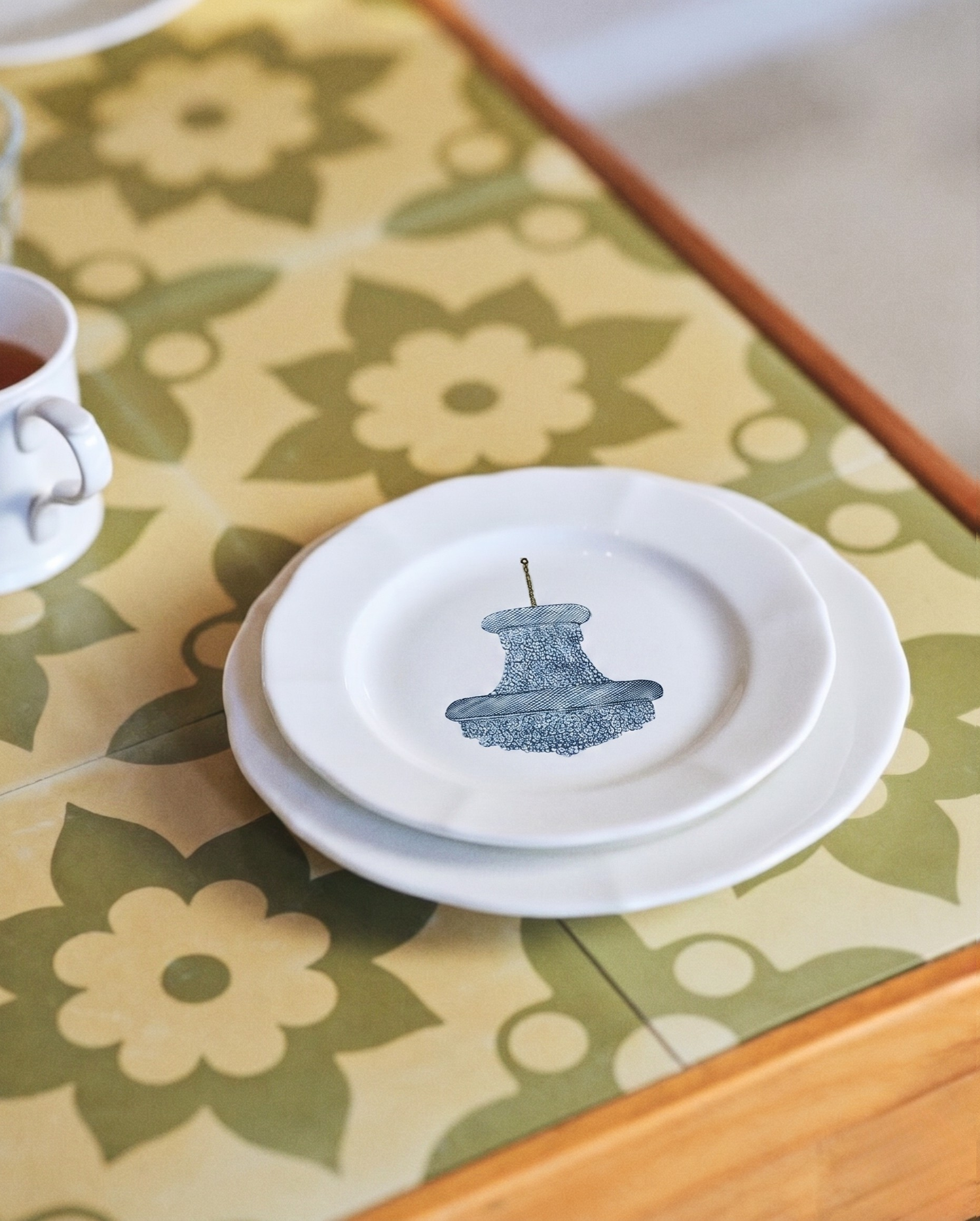 White plate with blue design on a floral tablecloth