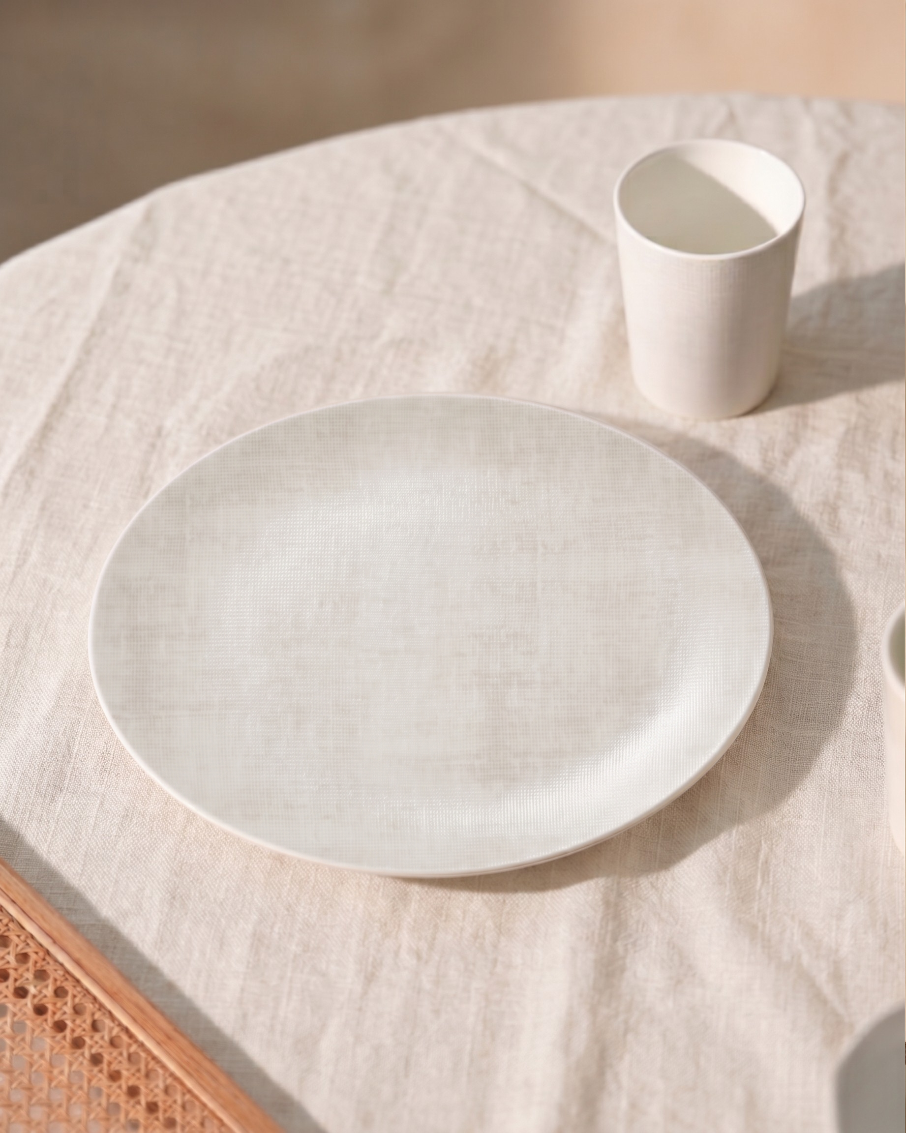 White ceramic plate and cup on a textured surface