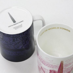 Two mugs, one black and white patterned, the other with a colorful design, on a light gray background.